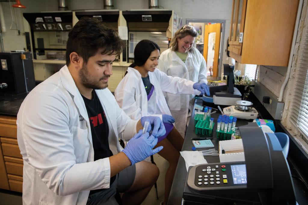 Students and their professor test samples collected in the field.